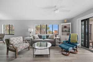 a living room with a couch and chairs and a table at Sandpiper Beach 101 in Sanibel