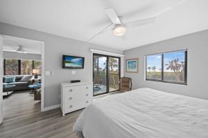 a bedroom with a bed and a living room at Sandpiper Beach 101 in Sanibel +48 photos