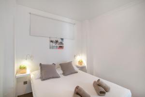 サン・バルトロメにあるApartamento Yumbo Playa Del Inglesの白いベッドルーム(大きな白いベッド、靴付)