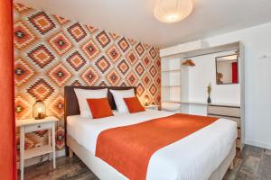 een slaapkamer met een groot bed en een oranje deken bij Les Bicoques à la mer - "Un air de Bicoque" in Dives-sur-Mer