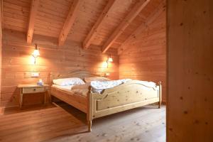 a bedroom with a bed in a wooden room at 1A Chalet Koralpenglück Wandern, Grillen und Indoor Sauna in Elsenbrunn
