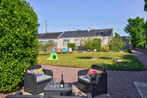 een achtertuin met 2 stoelen en een speeltuin bij Les Bicoques à la mer - "Un air de Bicoque" in Dives-sur-Mer