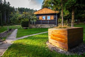 a house with a tree in a wooden box at Chatová osada Ostaš in Police nad Metují