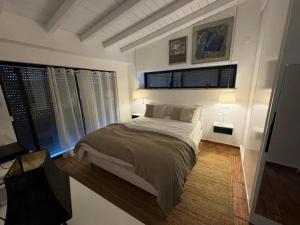 a bedroom with a bed and two windows at Cozy house in São Brás de Alportel with shared pool 60 m² in São Brás de Alportel +26 photos