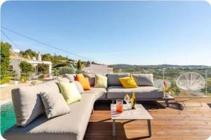 a white couch with colorful pillows on a patio at Cozy house in São Brás de Alportel with shared pool 60 m² in São Brás de Alportel
