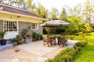 a patio with a table and an umbrella at 3 Bedroom Bungalow Zawadi Place in Nairobi