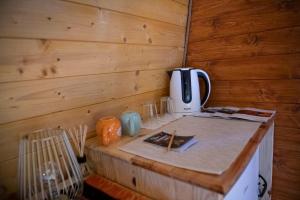 a room with a wooden wall with a coffee maker at Bungalov Sara Kamena Gora in Prijepolje