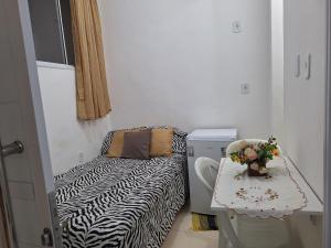 Camera piccola con letto a stampa zebra e tavolo di Linda Kitnet Mobiliada 03 a Salvador