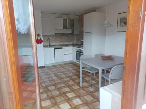 a kitchen with white cabinets and a table and chairs at Casa Erica - Carano in Carano +25 photos