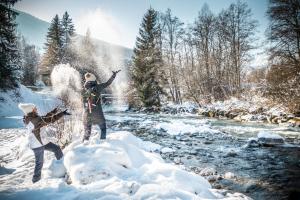 two people standing in the snow next to a river at Huttopia Champagny en Vanoise in Champagny-en-Vanoise