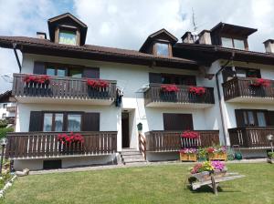 a house with balconies and red flowers in the yard at Casa Erica - Carano in Carano