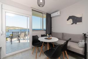 a living room with a couch and a table and chairs at Mikelanna Aegean Skyline in Neos Marmaras
