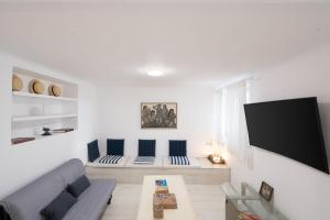 a living room with a couch and a flat screen tv at The House on the Hill in Athens