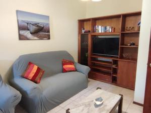 Una sala de estar con un sofá y un televisor de pantalla plana. en Casa Amplia Avenida Solari, en La Paloma