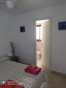 a bedroom with a bed with a pink suitcase on it at Eli's Home in Málaga