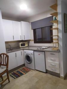 a kitchen with white cabinets and a washing machine at Eli's Home in Málaga