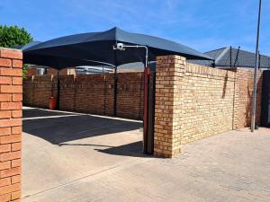 a black umbrella on top of a brick fence at Hillcrest Hosting AirBnB in Kimberley +1 photo