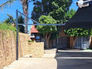 a brick wall with a security camera in front of a house at Hillcrest Hosting AirBnB in Kimberley