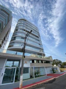 a tall building with a street light in front of it at Guarapari Bacutia Peracanga an1 in Guarapari