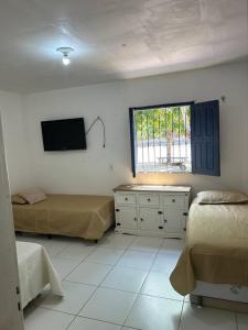 ein Schlafzimmer mit zwei Betten und einem Fernseher an der Wand in der Unterkunft Sítio zona rural de Teresina in Teresina