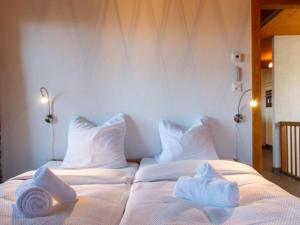 a white bed with towels on top of it at Chalet Beke by Interhome in Nendaz
