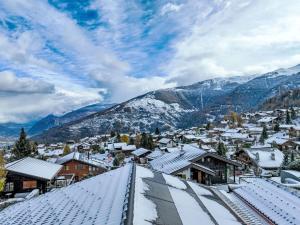 a town covered in snow with mountains in the background at Chalet Beke by Interhome in Nendaz