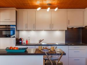 a kitchen with white cabinets and a counter top at Chalet Beke by Interhome in Nendaz +38 photos