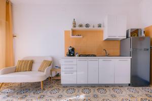 a kitchen with a chair and a refrigerator at Appartamento Mare Blu in Sciacca
