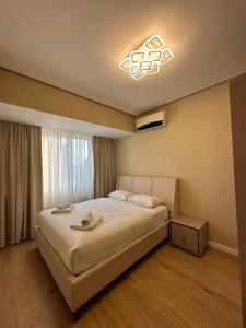 a bedroom with a large bed with a light at Prime Suites in Bishkek