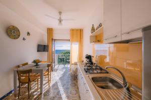a kitchen with a sink and a table with chairs at Appartamento Mare Blu in Sciacca