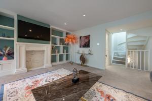 a living room with a fireplace and a tv at GRAND 200 SqM 3-Bedroom VILLA in London
