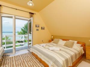 a bedroom with a large bed and a balcony at Holiday Home Hanna by Interhome in Balatonlelle