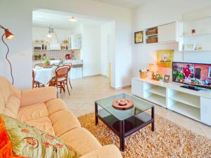 a living room with a couch and a tv and a table at Apartment Moira-1 by Interhome in Ika