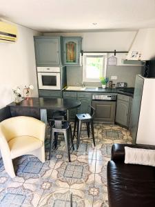 a kitchen with green cabinets and a table and chairs at Maison en rez de jardin - L'Écrin Provençal in Puget-sur Argens