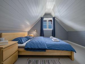 a bedroom with a bed with blue sheets and a window at Holiday Home Tor by Interhome in Arnefjord