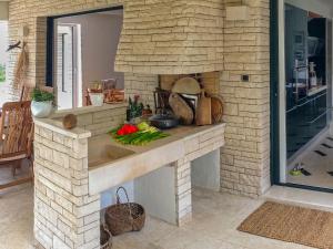 een keuken met een stenen open haard en een wastafel bij Villa Kamik by Interhome in Kostrena