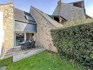 a patio with a table and chairs on a brick wall at Apartment Les Alizés-1 by Interhome in Carnac-Plage