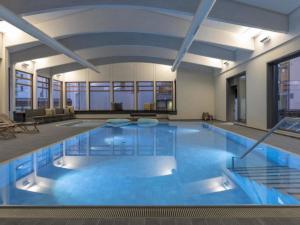 a large pool with blue water in a building at Apartment Schweizerhof Drescher by Interhome in Lenzerheide