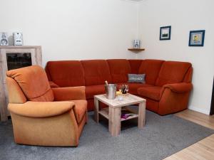 a living room with a couch and a table at Holiday Home Kiel by Interhome in Norddeich