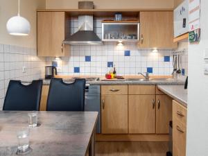 a kitchen with wooden cabinets and a counter top at Holiday Home Kiel by Interhome in Norddeich