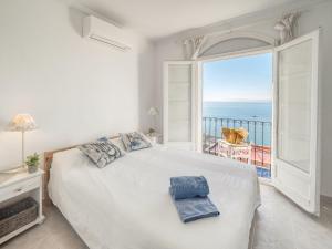 Un dormitorio con una gran cama blanca y una gran ventana. en Holiday Home Los Geranios by Interhome, en Roses