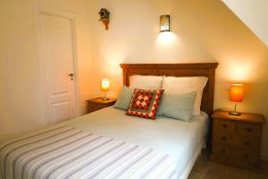a bedroom with a bed with two lamps on two night stands at Fonte do Cabo Apartment in Ericeira