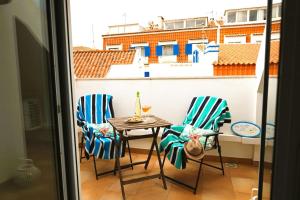 a balcony with two chairs and a table and a window at Fonte do Cabo Apartment in Ericeira