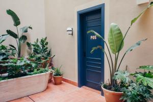 a garden with plants and a blue door at Hotel Casa Bonay in Barcelona