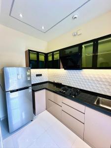 a kitchen with a refrigerator and a sink at Peacock Palace 2BHK Modern AC Flat in Baner Pune in Pune +26 photos