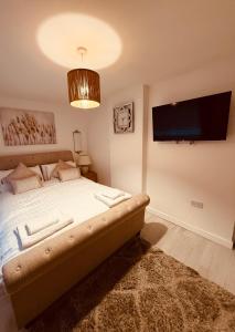 a bedroom with a bed and a flat screen tv at Beach house in Newcastle upon Tyne