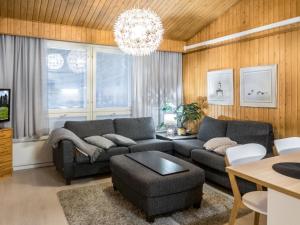 ein Wohnzimmer mit einer Couch und einem Kronleuchter in der Unterkunft Holiday Home Lomakatti 10b by Interhome in Vuokatti