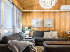ein Wohnzimmer mit einer Couch und einem Kronleuchter in der Unterkunft Holiday Home Lomakatti 10b by Interhome in Vuokatti