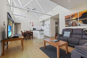 a living room with a couch and a table at Despatch - Waterfront Retreat in Goon Nure