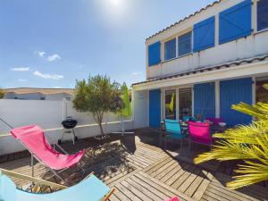 a patio with chairs and a table on a building at À 550m de la plage, jolie maison pour 5 in Plage-des-Demoiselles